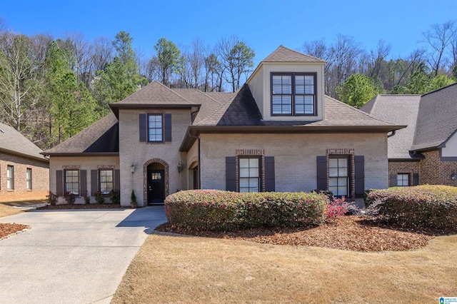 view of front of property featuring brick siding and a shingled roof