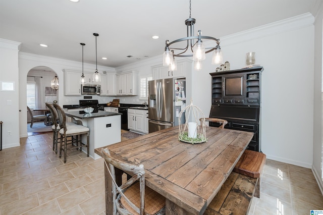 dining area with arched walkways, a notable chandelier, baseboards, and ornamental molding