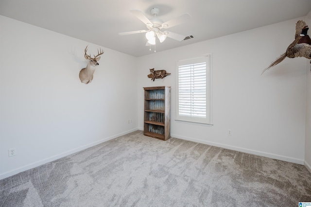 spare room with visible vents, baseboards, carpet, and a ceiling fan