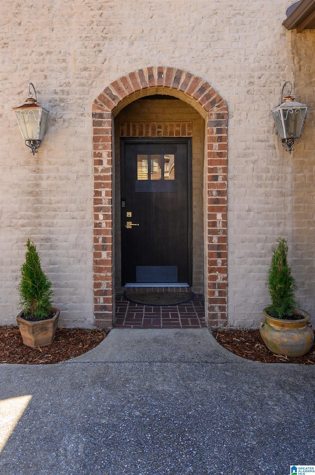 property entrance featuring brick siding