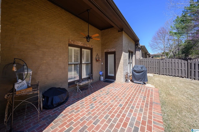 view of patio / terrace with a grill, a ceiling fan, and fence