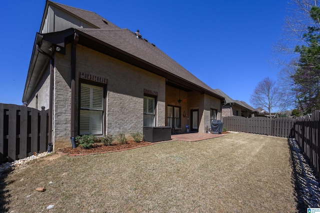 view of side of property featuring stucco siding, central AC unit, a fenced backyard, and a patio area