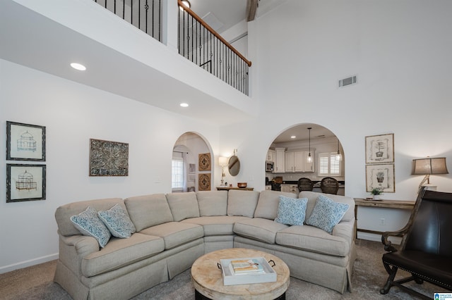 living area featuring visible vents, recessed lighting, arched walkways, carpet floors, and baseboards