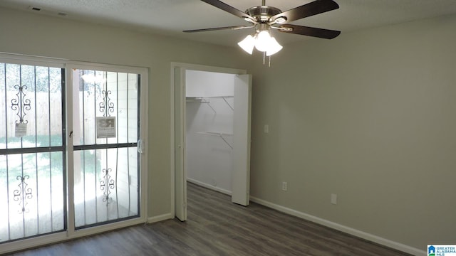 unfurnished bedroom featuring visible vents, ceiling fan, baseboards, wood finished floors, and a closet