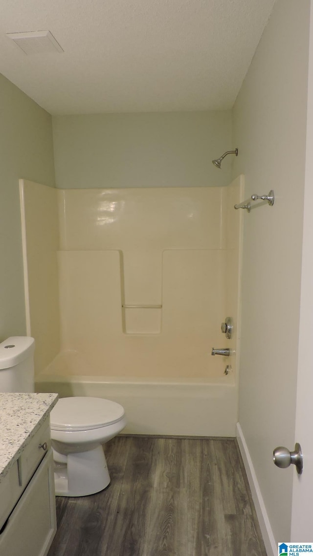 full bathroom with toilet, vanity,  shower combination, and wood finished floors