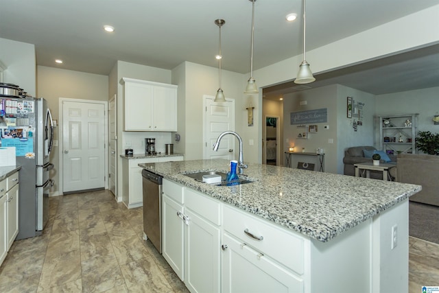 kitchen with a sink, light stone counters, recessed lighting, appliances with stainless steel finishes, and white cabinets