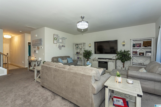 living area with an inviting chandelier, stairway, light colored carpet, and baseboards