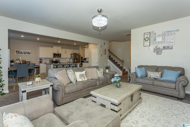 living room featuring stairway and light carpet