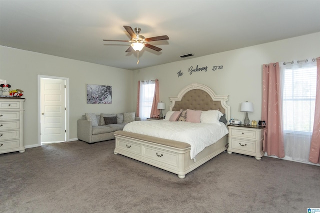 bedroom with a ceiling fan, visible vents, dark colored carpet, and baseboards