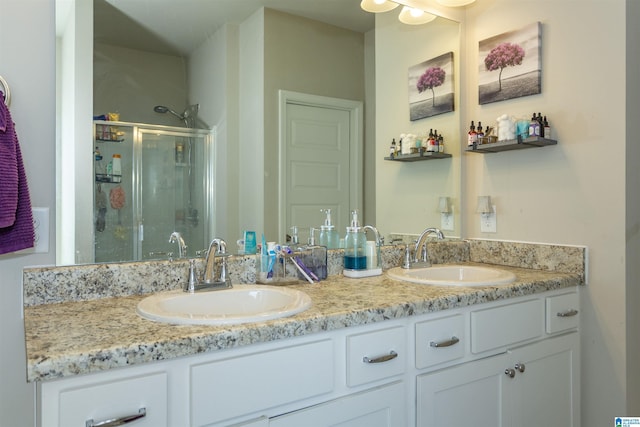 bathroom featuring a sink, double vanity, and a shower stall