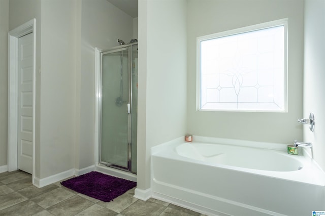 full bathroom featuring tile patterned flooring, a shower stall, a garden tub, and baseboards