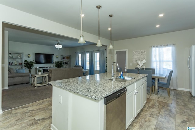 kitchen with a sink, a healthy amount of sunlight, freestanding refrigerator, and stainless steel dishwasher