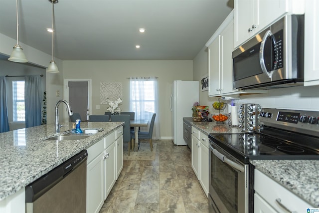 kitchen featuring plenty of natural light, white cabinets, appliances with stainless steel finishes, and a sink