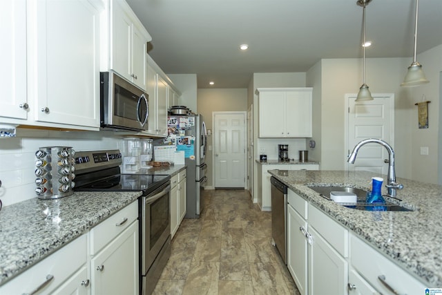 kitchen with a sink, backsplash, appliances with stainless steel finishes, and white cabinetry