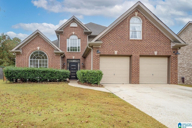 traditional-style home with brick siding, driveway, a front lawn, and roof with shingles