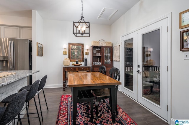 dining space featuring french doors, dark wood-type flooring, and an inviting chandelier