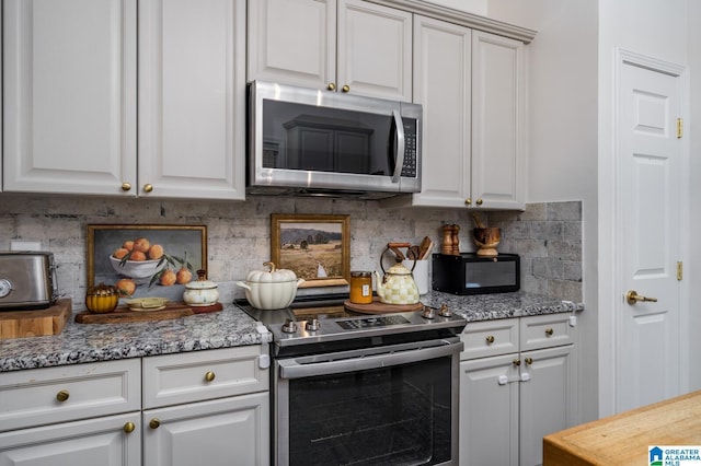 kitchen featuring decorative backsplash, white cabinets, and stainless steel appliances