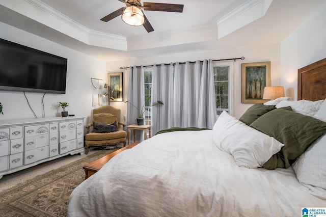 bedroom featuring a raised ceiling, ornamental molding, and a ceiling fan