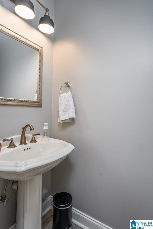 bathroom featuring baseboards and a sink