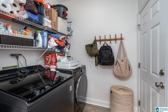 clothes washing area with laundry area, wood finished floors, baseboards, and independent washer and dryer