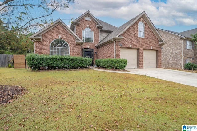 traditional-style home with fence, roof with shingles, concrete driveway, a front yard, and brick siding