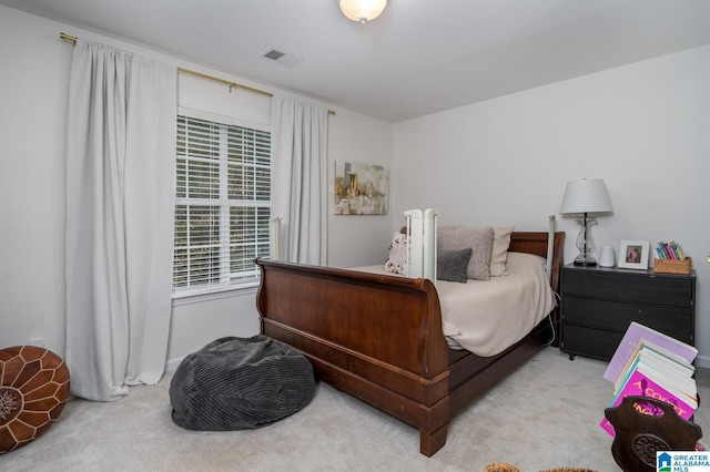 carpeted bedroom featuring visible vents