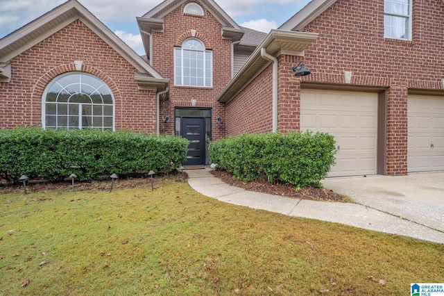 traditional-style house featuring brick siding, an attached garage, concrete driveway, and a front yard