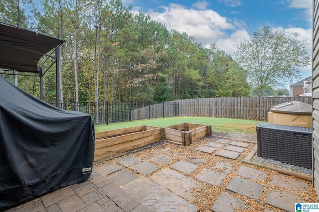 view of patio with area for grilling, a garden, and a fenced backyard