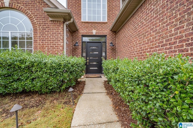 view of exterior entry featuring brick siding