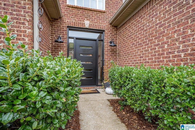 doorway to property featuring brick siding