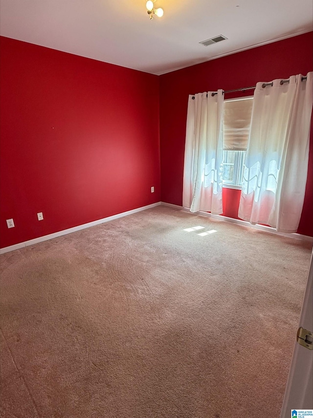 carpeted empty room with visible vents and baseboards