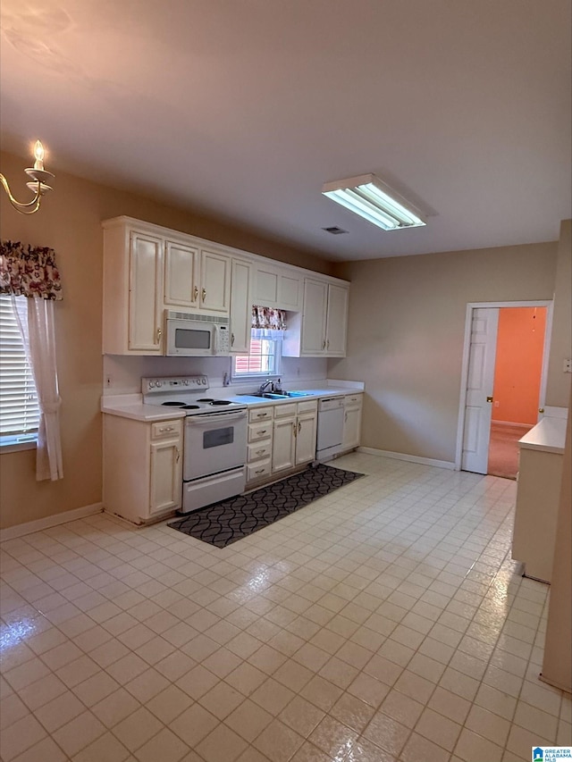 kitchen featuring a sink, baseboards, white appliances, and light countertops