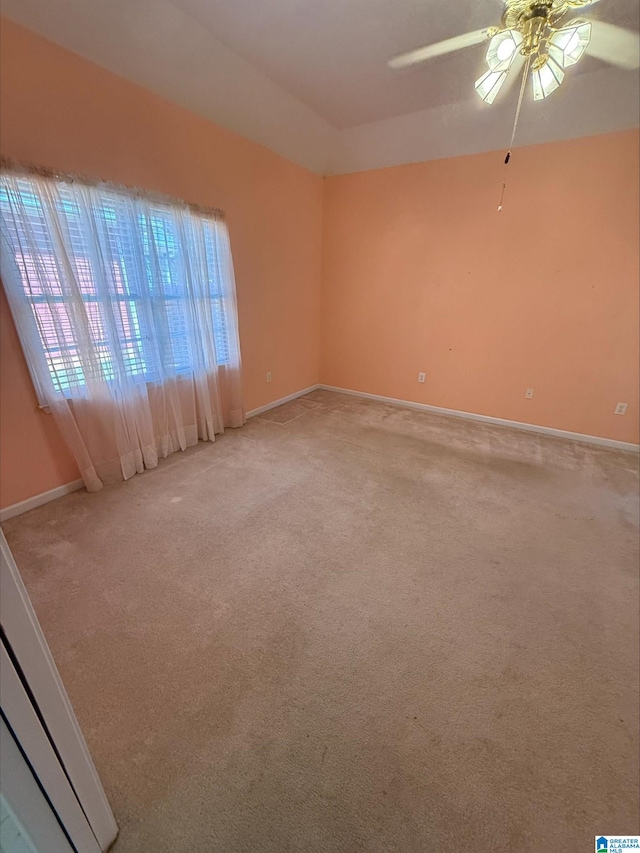 empty room with baseboards, light carpet, and ceiling fan