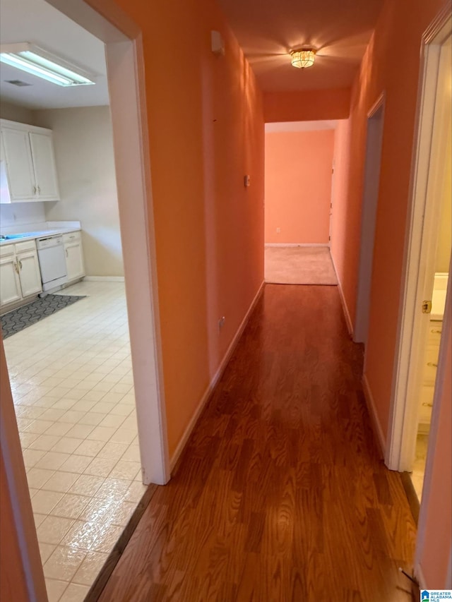 corridor featuring baseboards and wood finished floors