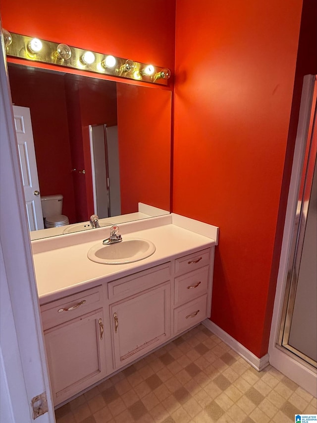 bathroom with tile patterned floors, toilet, vanity, and baseboards