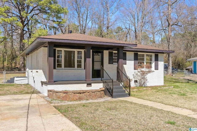 view of front of property with a front lawn, fence, brick siding, and crawl space