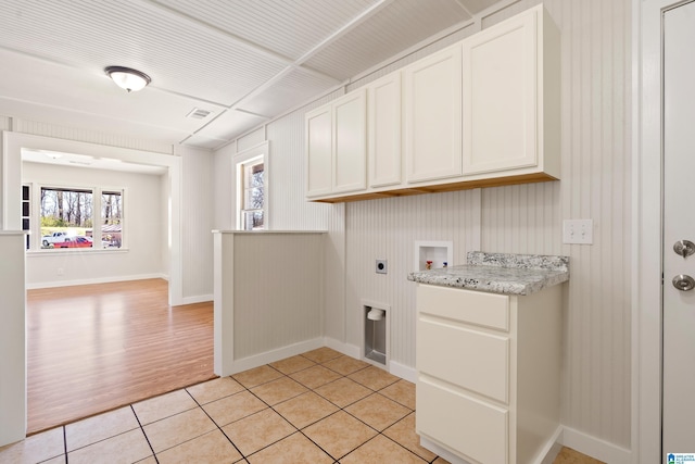 laundry area featuring visible vents, light tile patterned flooring, cabinet space, electric dryer hookup, and washer hookup