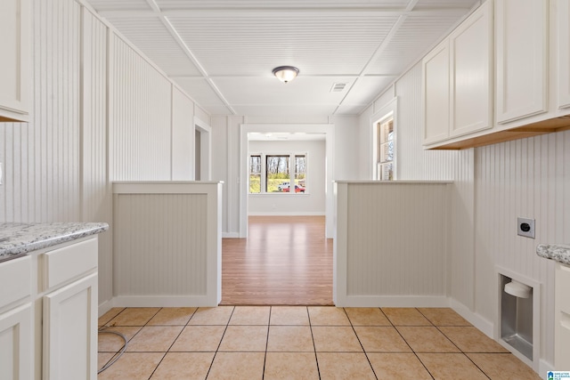 interior space with visible vents, baseboards, light tile patterned floors, cabinet space, and hookup for an electric dryer