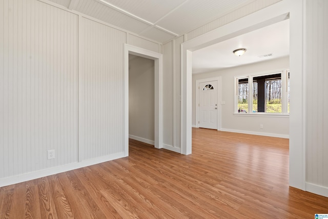 unfurnished room with baseboards, visible vents, and light wood finished floors