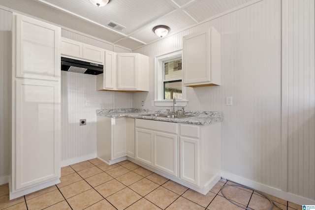 kitchen with a sink, visible vents, white cabinets, and light tile patterned floors