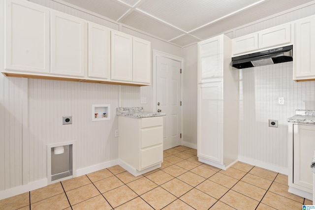 laundry area with cabinet space, hookup for an electric dryer, hookup for a washing machine, and light tile patterned flooring