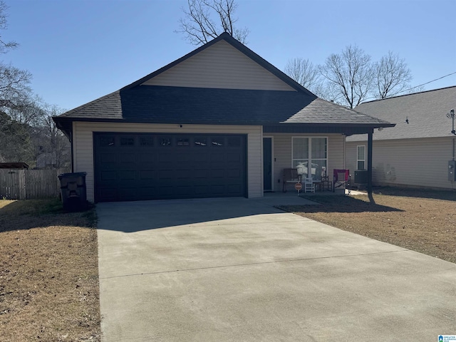 view of front of home featuring fence, roof with shingles, covered porch, concrete driveway, and a garage