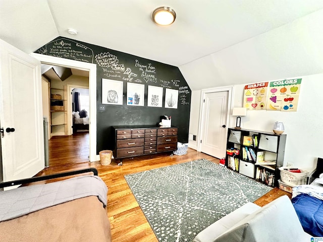 bedroom with vaulted ceiling and wood finished floors