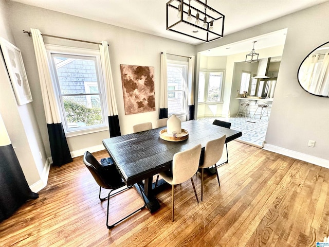 dining area featuring baseboards and light wood finished floors