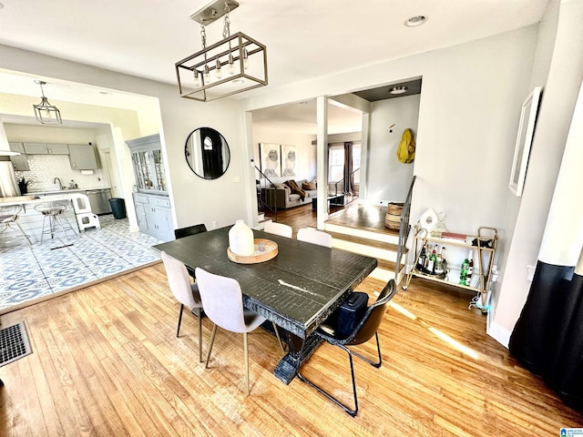 dining room featuring visible vents, baseboards, and light wood-style floors