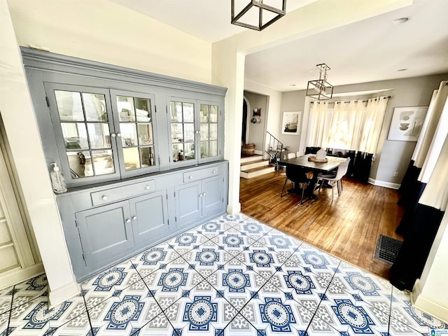 dining space with stairway, a healthy amount of sunlight, light wood-type flooring, and baseboards