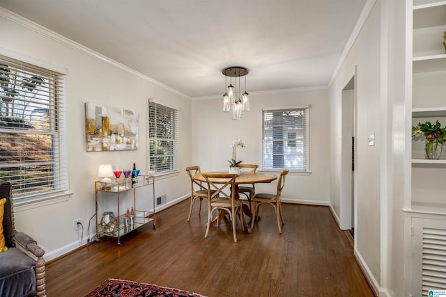 dining area featuring dark wood finished floors, baseboards, visible vents, and ornamental molding