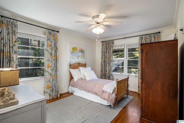 bedroom with ceiling fan, crown molding, baseboards, and wood finished floors