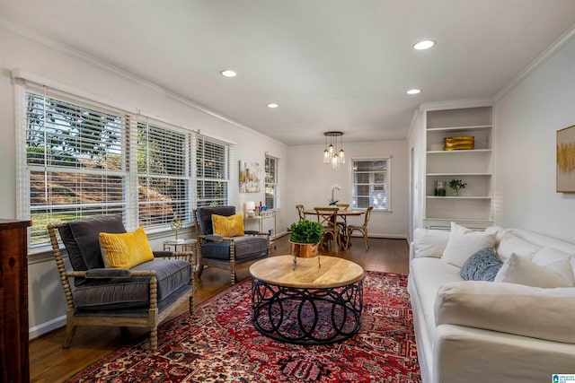 living area with built in shelves, wood finished floors, recessed lighting, crown molding, and baseboards