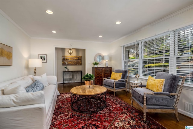 living room with a healthy amount of sunlight, wood finished floors, and crown molding